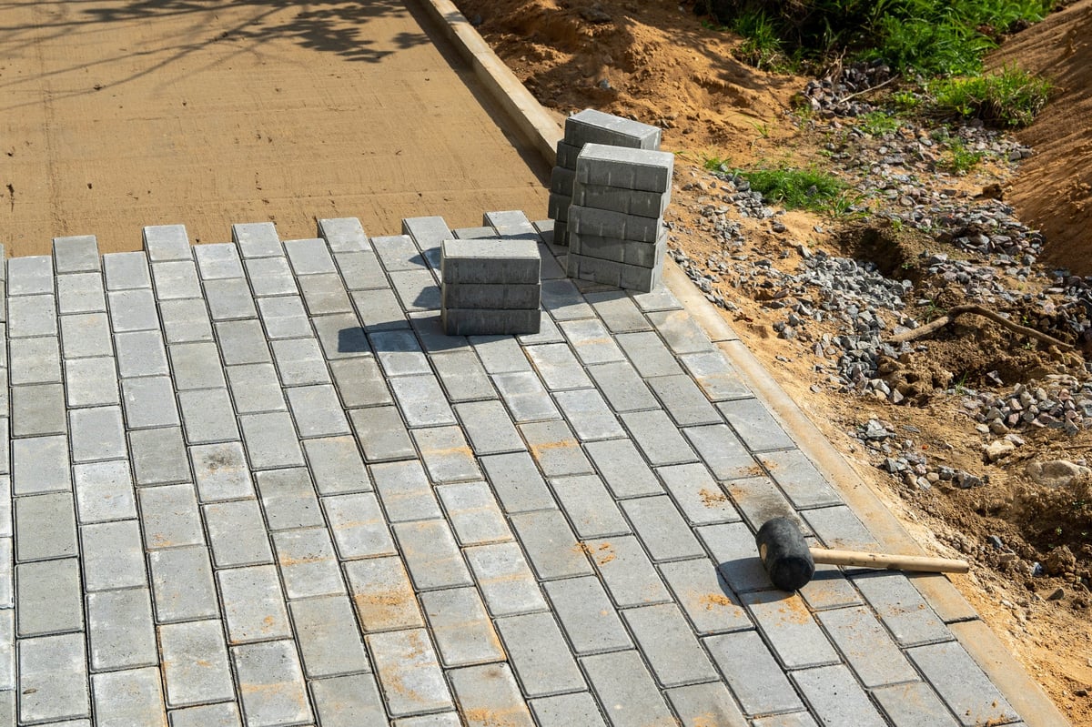 Contractor laying brick for a new pathway on a construction site
